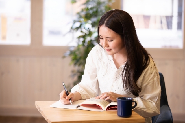 自己啓発･e-ラーニングのイメージ画像(女性がカフェで勉強に励む画像)